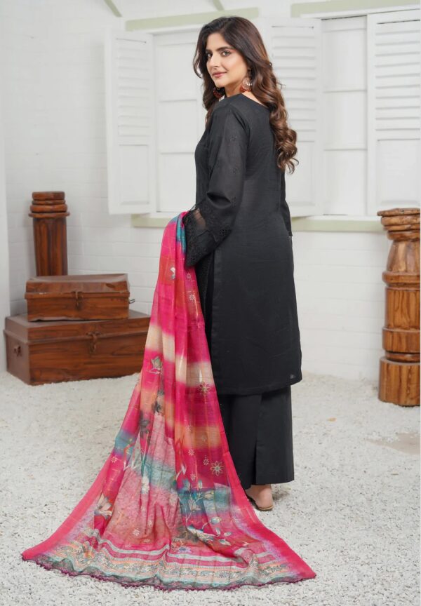 A woman Summer dress in a black suit in a multi-color dupatta stands in a room in front of a window, posing for a photo shoot from the front of the black suit.